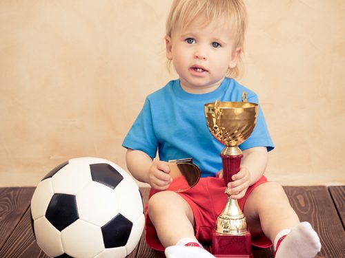 Child is pretending to be a soccer player. Success and winner concept